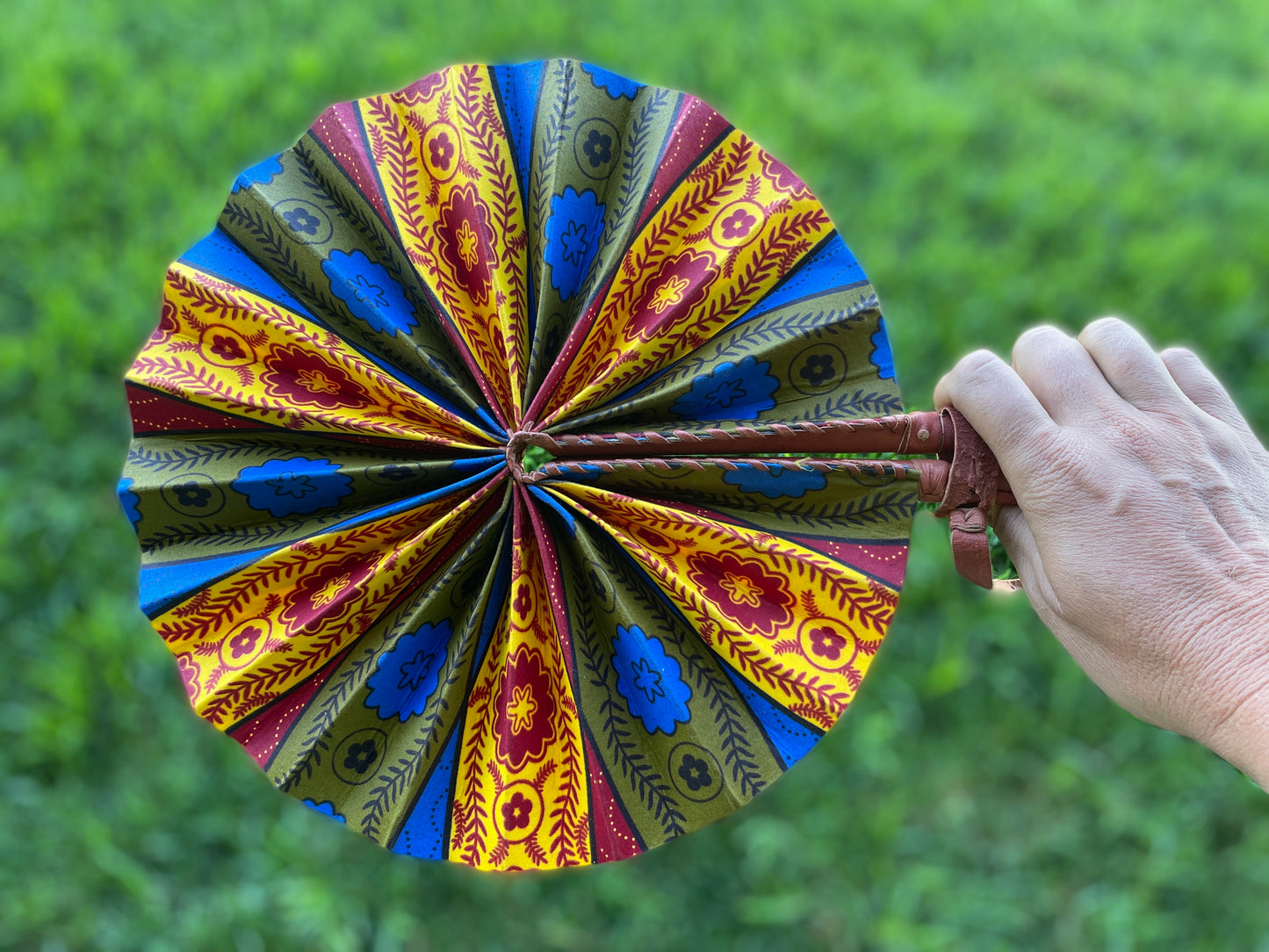 African wax print artisan fan in red, yellow, and blue
